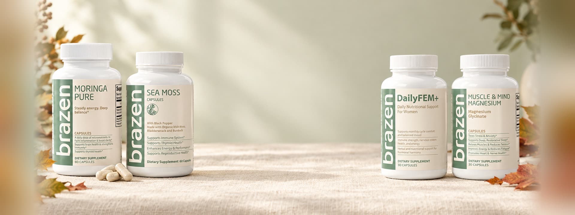 Moringa Pure, Sea Moss Capsules, DailyFEM+ and Muscle & Mind Magnesium bottles on a linen table with autumn leaves