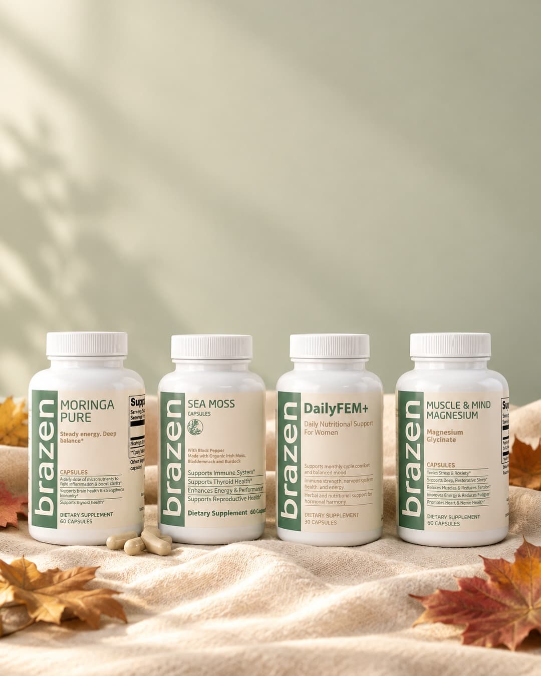 Moringa Pure, Sea Moss Capsules, DailyFEM+ and Muscle & Mind Magnesium bottles on a linen throw with autumn leaves
