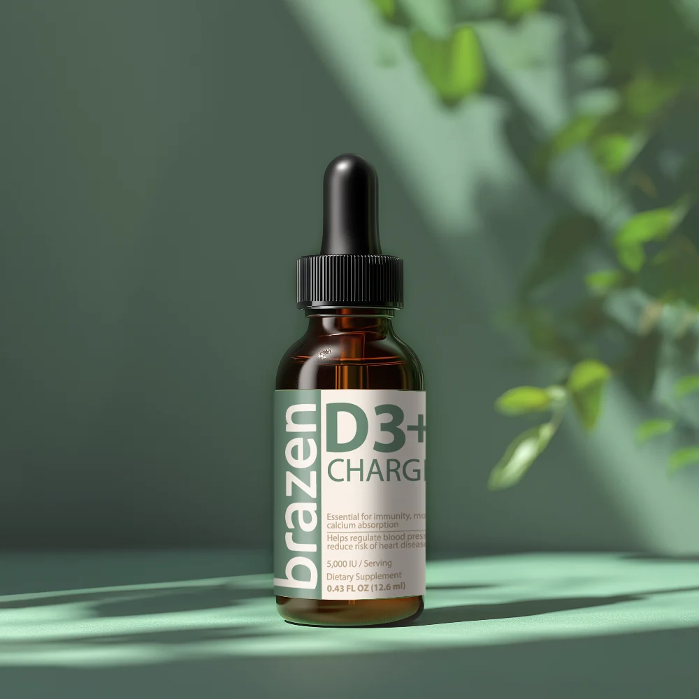 Amber dropper bottle of Brazen D3+ Charge on a green surface with dappled leaf shadows