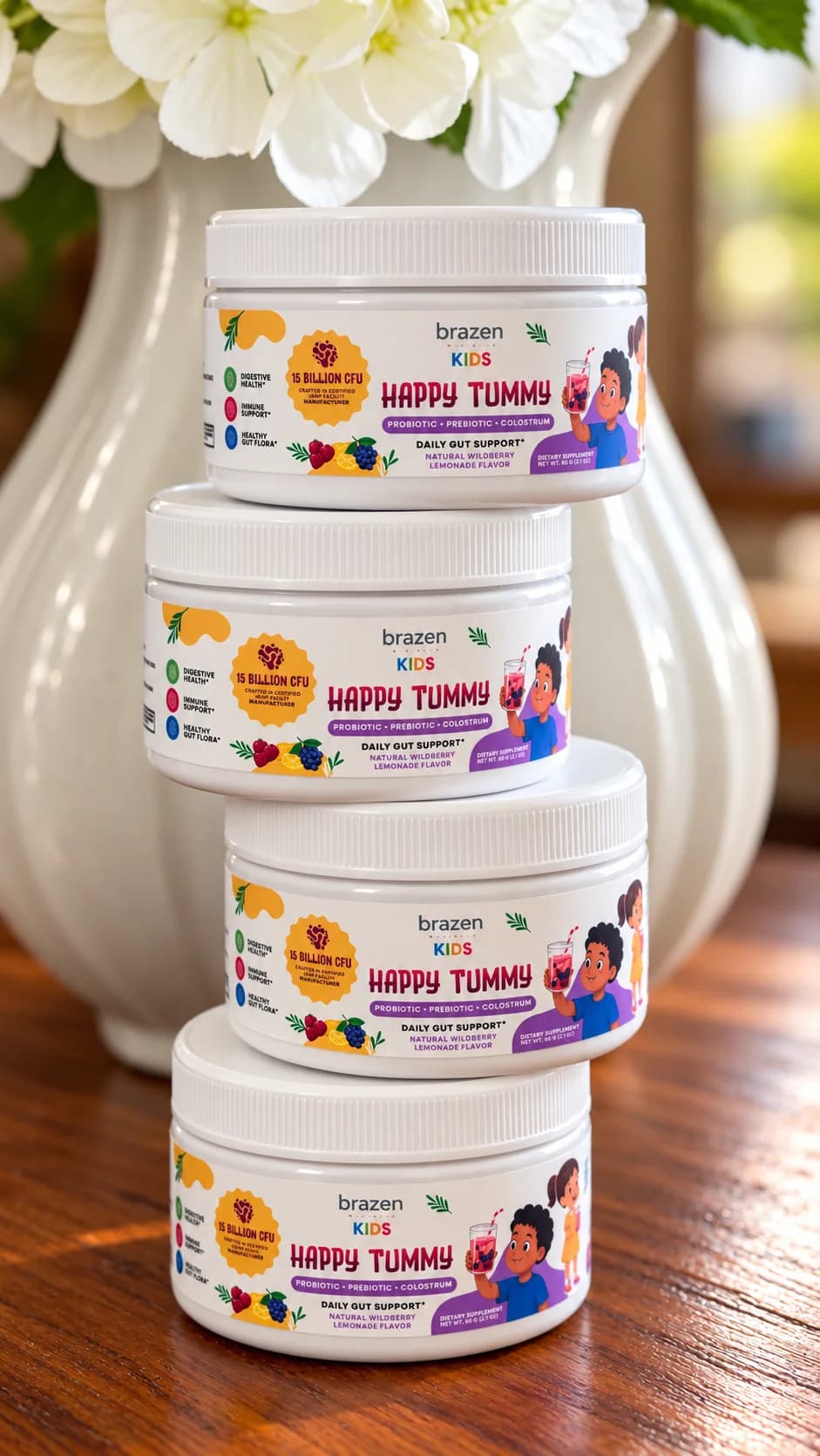 Four tubs of Brazen Kids Happy Tummy in Natural Wildberry Lemonade stacked on a wooden table beside a white vase
